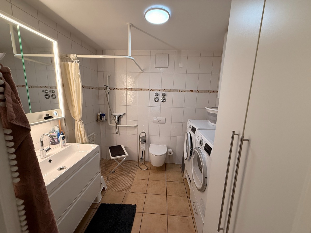 Bad mit Dusche und Waschmaschine und Trocknerstellplatz