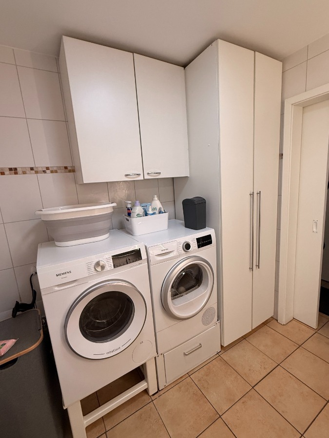 Bad mit Dusche und Waschmaschine und Trocknerstellplatz